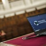 Computadora portátil sobre una mesa de madera Descripción generada automáticamente con confianza media